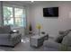 Comfortable living room featuring a mounted TV, large window, and cozy seating arrangement at 104 S Tunstall St, Apex, NC 27502