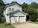 Traditional two-story home featuring a two-car garage, light blue siding, well-maintained yard, and mature trees for added privacy at 10415 Neland, Raleigh, NC 27614