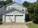 Traditional two-story home featuring a two-car garage, light blue siding, well-maintained yard, and mature trees at 10415 Neland, Raleigh, NC 27614