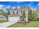 Charming two-story home with a well-manicured lawn, inviting entrance, and attached two-car garage at 106 Flue Ct, Oxford, NC 27565