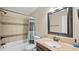 Bright bathroom featuring a granite countertop, tiled tub/shower combo and stylish mirror at 11 Willow Bridge Dr, Durham, NC 27707
