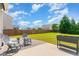 Relax in the backyard featuring a stone patio with seating and a planter with a lush lawn at 1108 Forest Willow Ln, Morrisville, NC 27560