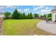 Spacious backyard features a well-manicured lawn, bordered by tall trees and a stone patio at 1108 Forest Willow Ln, Morrisville, NC 27560
