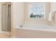 Modern bathroom features a soaking tub beneath a window, plus glass enclosed shower at 1108 Forest Willow Ln, Morrisville, NC 27560