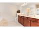 Bright bathroom featuring a double vanity with dark wood cabinets and neutral countertops at 1108 Forest Willow Ln, Morrisville, NC 27560