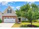 Charming home with a brick and vinyl exterior, two-car garage, mature trees, and well-maintained landscaping at 1108 Forest Willow Ln, Morrisville, NC 27560