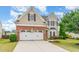 Beautiful two-story home featuring a two-car garage, brick accents, manicured lawn, and mature landscaping at 1108 Forest Willow Ln, Morrisville, NC 27560