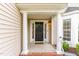 Welcoming front porch with classic columns, a dark wood door, and sidelights, enhancing curb appeal at 1108 Forest Willow Ln, Morrisville, NC 27560