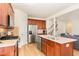 Kitchen with wood cabinets, stainless appliances, island with sink and access to the living room at 1108 Forest Willow Ln, Morrisville, NC 27560