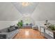 Finished attic featuring hardwood flooring, ample lighting, and comfortable couches at 113 Chestone Ct, Cary, NC 27513