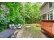 Expansive backyard featuring mature trees, outdoor seating, and relaxing swing set at 113 Chestone Ct, Cary, NC 27513