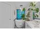 Modern bathroom with a freestanding tub, decorative chandelier, and a large tropical plant at 113 Chestone Ct, Cary, NC 27513