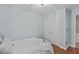 Bedroom offers hardwood floors, closet, modern light fixture, and an adjacent bathroom at 113 Chestone Ct, Cary, NC 27513