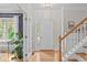 Bright foyer with hardwood floors, elegant staircase, white door, and stylish decor at 113 Chestone Ct, Cary, NC 27513