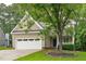 Charming two-story home with a neutral facade, a two-car garage, and a well-manicured lawn and mature trees at 113 Chestone Ct, Cary, NC 27513
