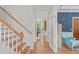 Hallway with hardwood floors, staircase, and doorway leading to the adjacent office and kitchen at 113 Chestone Ct, Cary, NC 27513