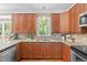 Bright kitchen features granite countertops, stainless appliances, tile backsplash, and warm wood cabinets at 113 Chestone Ct, Cary, NC 27513