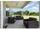 Covered back porch with outdoor seating and a view of the spacious backyard at 124 Airlie Place Ln, Willow Springs, NC 27592