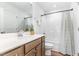 Well-lit bathroom with wood cabinets, white countertops, and a shower-tub combo at 124 Airlie Place Ln, Willow Springs, NC 27592