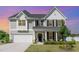 Charming two-story home featuring a welcoming front porch and manicured landscaping at 124 Airlie Place Ln, Willow Springs, NC 27592
