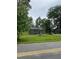 Charming gray house nestled among mature trees with a green lawn at 12600 Old Stage Rd, Willow Springs, NC 27592