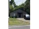 Single-story home with a dark-colored roof, a small yard and a dark car at 12600 Old Stage Rd, Willow Springs, NC 27592