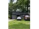 Cozy gray home with a dark roof, surrounded by lush greenery and parked cars at 12600 Old Stage Rd, Willow Springs, NC 27592