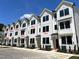 Multiple townhouses feature crisp white siding, dark-trimmed windows, and professionally landscaped yards at 1532 Crescent Townes Way, Raleigh, NC 27604