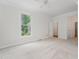 Bright bedroom features neutral carpet, a ceiling fan, and a large window overlooking green outdoor space at 1547 Village Glenn Dr, Raleigh, NC 27612