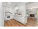 Well-lit kitchen featuring white cabinets, stainless steel appliances, and hardwood floors at 1547 Village Glenn Dr, Raleigh, NC 27612