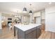 Open-concept kitchen with a large island, white countertops, and views of the dining and living areas at 1601 Merry Mdw Way, Wendell, NC 27591