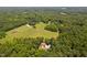 Aerial view of a house situated on land surrounded by lush trees and greenery at 1909 Ira Rd, Efland, NC 27243