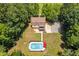 Aerial view of a home with a pool, long driveway, and large yard with mature trees at 1909 Ira Rd, Efland, NC 27243