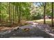 Backyard firepit with gravel, wooded views, and outdoor seating at 1909 Ira Rd, Efland, NC 27243