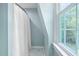 Bright bathroom with a marble tile floor, a shower with a white curtain, and a window overlooking the backyard at 1909 Ira Rd, Efland, NC 27243
