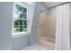 Light-filled bathroom with tile floors, a window with a view, and a combination tub and shower at 1909 Ira Rd, Efland, NC 27243