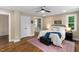 Bedroom with a ceiling fan, a neutral color scheme, wood floors, and access to a walk-in closet at 1909 Ira Rd, Efland, NC 27243