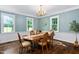 Traditional dining room with wood floors, chandelier, wainscotting, and windows overlooking the outdoor landscape at 1909 Ira Rd, Efland, NC 27243