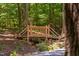 Wooden footbridge with railing crossing a small creek, surrounded by lush greenery at 1909 Ira Rd, Efland, NC 27243