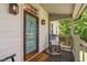 Inviting front porch featuring a comfortable rocking chair and a stylish blue front door at 1909 Ira Rd, Efland, NC 27243