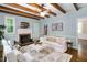 Cozy living room with exposed wood beams, fireplace with mantel, and comfortable seating at 1909 Ira Rd, Efland, NC 27243