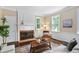 Living room featuring a fireplace with brick surround, wainscotting, two windows and hardwood floors at 1909 Ira Rd, Efland, NC 27243