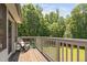 Outdoor deck with rocking chair and a view of the wooded backyard at 1909 Ira Rd, Efland, NC 27243