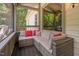 Comfortable outdoor screened porch features wicker furniture and colorful pillows at 1909 Ira Rd, Efland, NC 27243