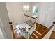 Wooden staircase with white banisters with views into another room and front door entrance at 1909 Ira Rd, Efland, NC 27243