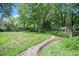 Large backyard features a stone path, lawn, lush landscaping, and a chicken coop at 203 W Hill Dr, Cary, NC 27519