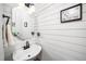 Charming half bathroom features shiplap walls, unique mirror, floating sink, and decorative art at 203 W Hill Dr, Cary, NC 27519