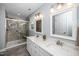 Bright bathroom features a glass shower, marble tile, quartz countertop, and double vanity at 203 W Hill Dr, Cary, NC 27519