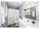 Bathroom features a shower with a white curtain, white vanity, and a large mirror above the sink at 203 W Hill Dr, Cary, NC 27519