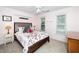 Well-lit bedroom features a decorative bed, light-pink walls, and two windows with tree-lined views at 203 W Hill Dr, Cary, NC 27519